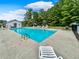 Community pool with sun loungers, and a secure fenced enclosure nestled in a lush treed setting at 6544 Amberwood Ct., Myrtle Beach, SC 29588