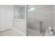 Bright bathroom featuring tiled shower, glass door, and a view from the window at 6591 Cagliari Court, Myrtle Beach, SC 29572