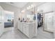 Bright bathroom featuring double sinks, walk-in closet access, and modern design elements at 6591 Cagliari Court, Myrtle Beach, SC 29572