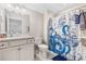 Bright bathroom featuring a white vanity, gray granite countertop, and a fun nautical themed shower curtain at 6591 Cagliari Court, Myrtle Beach, SC 29572