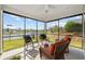 Relaxing screened-in porch with comfortable seating, ceiling fan, and serene lake views at 6591 Cagliari Court, Myrtle Beach, SC 29572