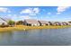 Picturesque view of homes along a lake, featuring well-kept lawns, mature trees, and screened-in porches at 6591 Cagliari Court, Myrtle Beach, SC 29572