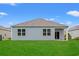 View of the home's rear exterior with large windows overlooking the expansive backyard at 662 Wallace Dr., Little River, SC 29566