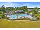 Aerial view of the community pool and clubhouse with lounge chairs and umbrellas at 662 Wallace Dr., Little River, SC 29566