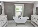 Bright bathroom featuring a freestanding tub, dual vanities, and stylish gray wood paneled walls at 675 Liberty Church Rd., Loris, SC 29569