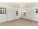 Bright bedroom featuring plush carpet, two windows, and a glass paneled door at 675 Liberty Church Rd., Loris, SC 29569