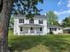 Charming home with a covered porch, black shutters, and green grass on a sunny day at 675 Liberty Church Rd., Loris, SC 29569
