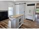 Bright kitchen with white cabinets, butcher block island, fireplace, and a modern barn door at 675 Liberty Church Rd., Loris, SC 29569
