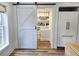 Walk-in pantry features a barn door and custom shelving for optimal storage and organization at 675 Liberty Church Rd., Loris, SC 29569