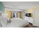 The bedroom features a comfortable bed, a TV with a dresser, and access to a balcony, providing all the comforts of home at 6804 N Ocean Blvd. # 1049, Myrtle Beach, SC 29572