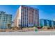 A multi-story apartment complex with a beach view, featuring balconies, palm trees, and ocean access at 6804 N Ocean Blvd. # 1049, Myrtle Beach, SC 29572