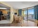 This dining area has a wooden table and chairs, a TV, and a balcony with a view of the ocean in the background at 6804 N Ocean Blvd. # 1049, Myrtle Beach, SC 29572
