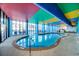 A vibrant indoor pool area with colorful ceilings, palm trees, and plenty of natural light at 6804 N Ocean Blvd. # 1049, Myrtle Beach, SC 29572