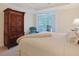 Bright bedroom with a cozy chair, balcony access, and elegant armoire at 719 Shearwater Ct. # 301, Murrells Inlet, SC 29576