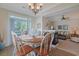 Dining room with wood table, chandelier, and abundant natural light from sliding doors to the exterior at 719 Shearwater Ct. # 301, Murrells Inlet, SC 29576