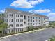 Beautiful condominium complex showcasing light siding, black shutters, large parking area, and manicured landscaping at 719 Shearwater Ct. # 301, Murrells Inlet, SC 29576