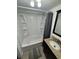 Bathroom featuring a tub and shower combination, a dark vanity, mirror, grey floor mat, and beige tile walls at 7509 N Ocean Blvd. # 1205, Myrtle Beach, SC 29572