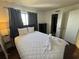 Bright bedroom with dark wood floors, a queen size bed, and swan towel art with a glimpse of the en suite bath at 7509 N Ocean Blvd. # 1205, Myrtle Beach, SC 29572