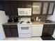 Kitchen with white appliances, dark cabinetry, mosaic backsplash, and ample counter space at 7509 N Ocean Blvd. # 1205, Myrtle Beach, SC 29572