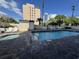 Outdoor community pool and hot tub with a paved deck and lounge chairs next to a building in the background at 7509 N Ocean Blvd. # 1205, Myrtle Beach, SC 29572