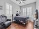 Bedroom with a ceiling fan, hardwood floors, two windows with blinds, and a sleek black bed at 830 Shine Ave. # 28 R8, Myrtle Beach, SC 29577