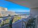 Relaxing balcony with seating area, offering stunning views of the ocean and neighboring buildings at 9820 Queensway Blvd. # 1603, Myrtle Beach, SC 29572