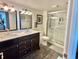 Beautiful bathroom with double sinks, dark cabinets, walk-in shower, and white walls at 9840 Queensway Blvd. # 1505, Myrtle Beach, SC 29572