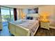 Inviting bedroom featuring a queen bed, nightstands, lamps, and a view of the beach at 9840 Queensway Blvd. # 1505, Myrtle Beach, SC 29572