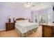 Spacious bedroom with a king bed, dresser, and two windows with wooded views at 1000 Ray Costin Way # 107, Garden City Beach, SC 29576