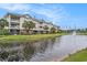 Condos with palm trees feature rear screened porches overlooking pond with water feature and golf course at 1000 Ray Costin Way # 107, Garden City Beach, SC 29576