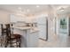 Cozy kitchen with breakfast bar, white cabinets, and an adjacent tiled hallway at 1000 Ray Costin Way # 107, Garden City Beach, SC 29576
