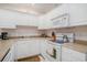 Bright kitchen with white cabinetry, tan countertops and modern appliances at 1000 Ray Costin Way # 107, Garden City Beach, SC 29576