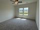 Bright bedroom with plush carpeting and a large window providing ample natural light at 1029 Jase Dr., Longs, SC 29568