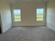 Well-lit bedroom with two windows offering scenic outdoor views and carpet at 1033 Jase Dr., Longs, SC 29568