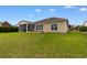 Expansive backyard featuring a screened-in porch, concrete patio, and well-maintained lawn at 1035 Brentford Pl., Myrtle Beach, SC 29579