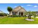 Charming single-story home with a well-manicured lawn, vibrant landscaping, and a stately palm tree at 1035 Brentford Pl., Myrtle Beach, SC 29579