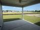 Covered back patio overlooking a spacious backyard with lush green grass and neighborhood views at 1037 Jase Dr., Longs, SC 29568