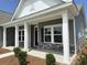 Inviting exterior of the home with a covered porch, gray siding, and manicured landscaping at 1037 Jase Dr., Longs, SC 29568