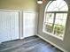 Bedroom featuring a large arched window, ceiling fan and two closets with gray wood floors at 104 Jessica Lakes Dr., Conway, SC 29526
