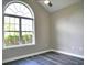 Bedroom features large arched window with gray wood floors and ceiling fan at 104 Jessica Lakes Dr., Conway, SC 29526