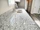 Close-up of granite countertops and stainless steel sink fixtures, showcasing modern kitchen design at 104 Jessica Lakes Dr., Conway, SC 29526
