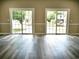 Living room featuring two sliding doors with gray wood floors and neutral paint at 104 Jessica Lakes Dr., Conway, SC 29526