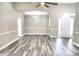Open-concept living area with grey vinyl floors, ceiling fans and natural lighting from several windows at 104 Jessica Lakes Dr., Conway, SC 29526