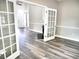 Spacious living room featuring grey vinyl floors, fireplace, and french doors that lead to the entry at 104 Jessica Lakes Dr., Conway, SC 29526