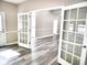 Spacious living room featuring grey vinyl floors, and french doors that lead to other rooms at 104 Jessica Lakes Dr., Conway, SC 29526