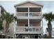 Charming coastal home featuring double balconies, white railings, and palm trees at 112 B 12Th Ave. N, Surfside Beach, SC 29575