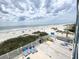 Panoramic view of a beach, blue water, and cloudy sky, with deck and lounge chairs in foreground at 116 S Waccamaw Dr. # 205, Murrells Inlet, SC 29576
