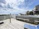 Beautiful beach view from a wooden deck with white picket fence, bench, and blue lounge chair at 116 S Waccamaw Dr. # 205, Murrells Inlet, SC 29576