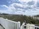 Beautiful beach and pier view from a sandy dune and white porch railing at 116 S Waccamaw Dr. # 205, Murrells Inlet, SC 29576