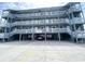 Attractive three story building with ample covered parking and stairs leading up to covered walkways in front of each unit at 116 S Waccamaw Dr. # 205, Murrells Inlet, SC 29576